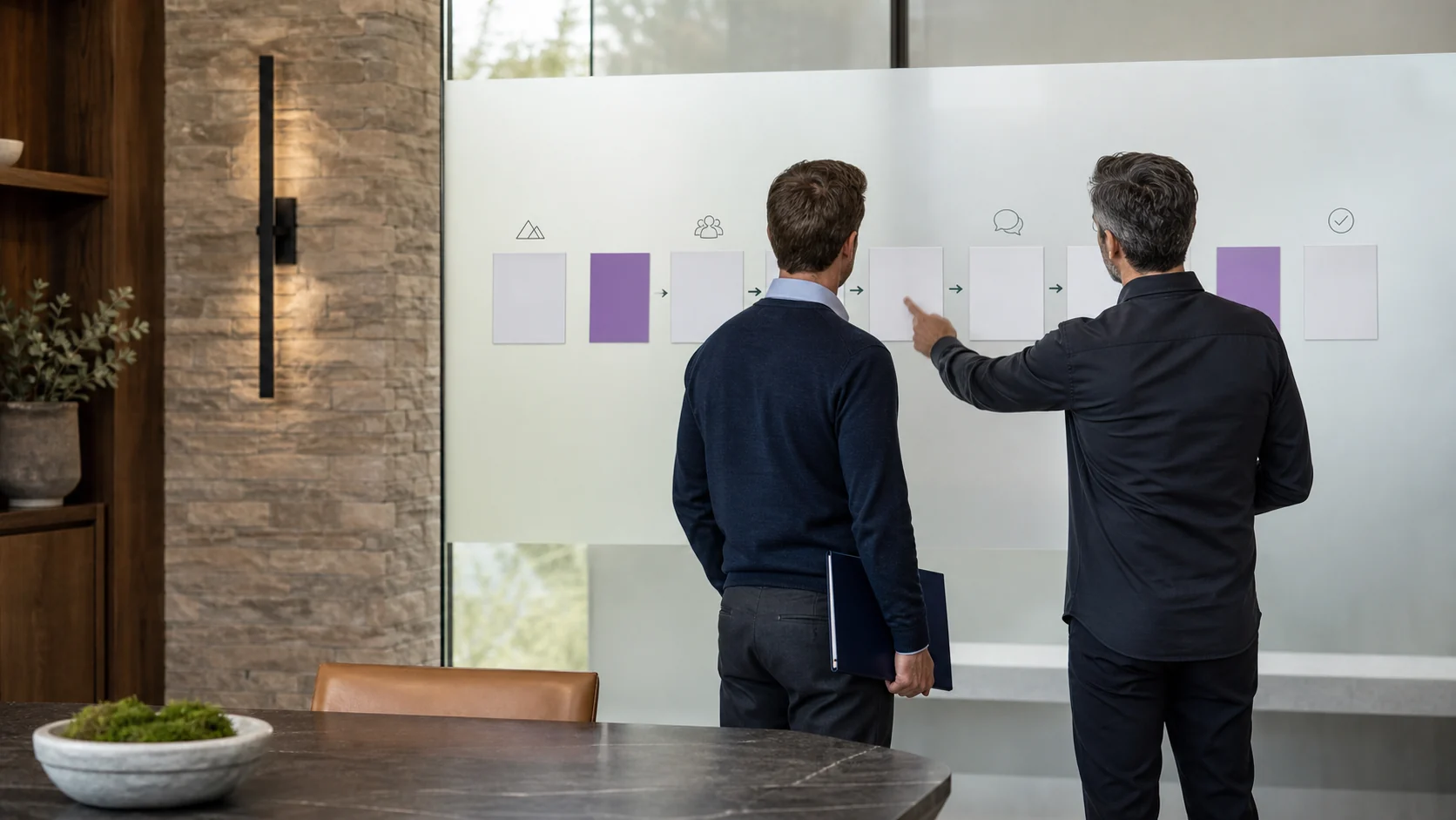 Founder and advisor reviewing a blank transaction plan on frosted glass